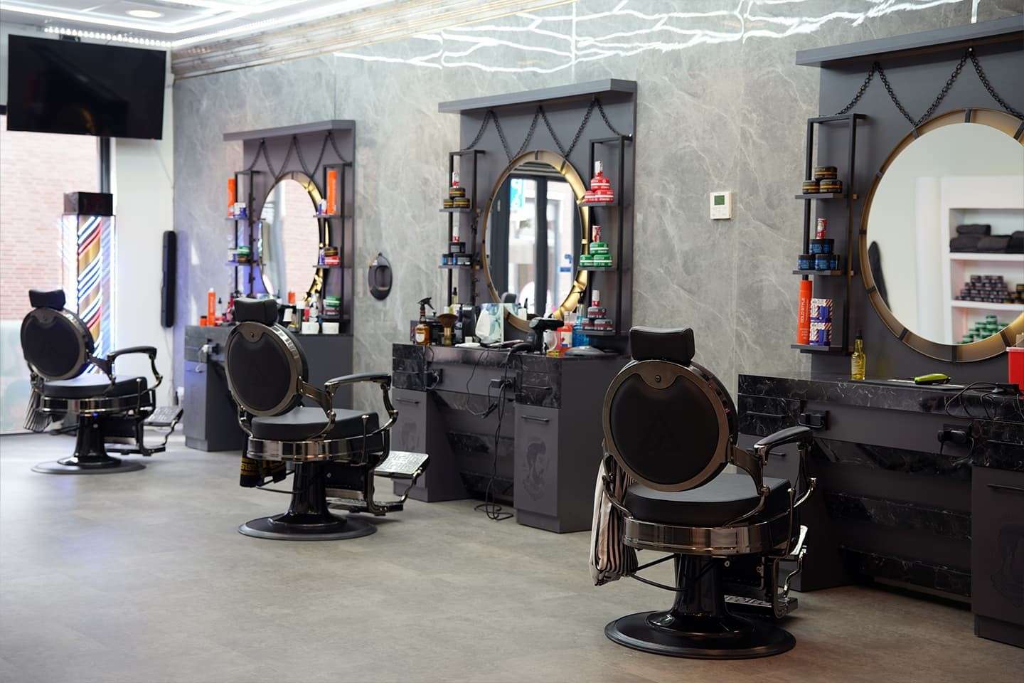 Drie barberstoelen met ronde spiegels bij City Style Barbershop aan de Promenade