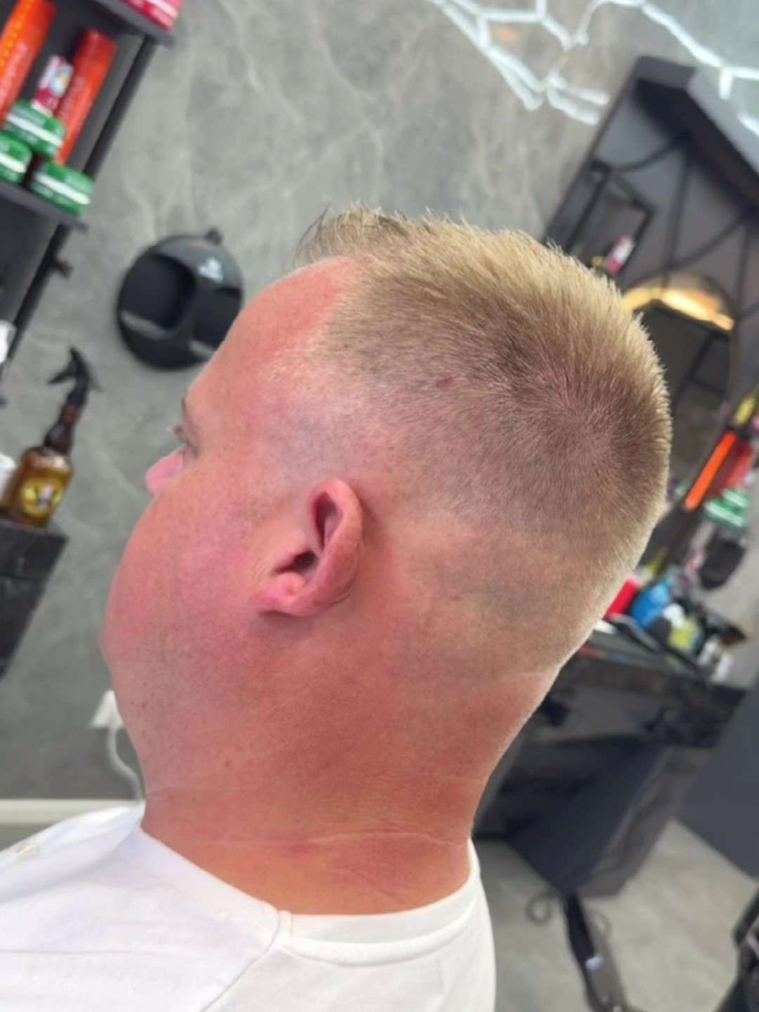 Kort geknipt blond haar met een fade, van opzij gezien, bij City Style Barbershop