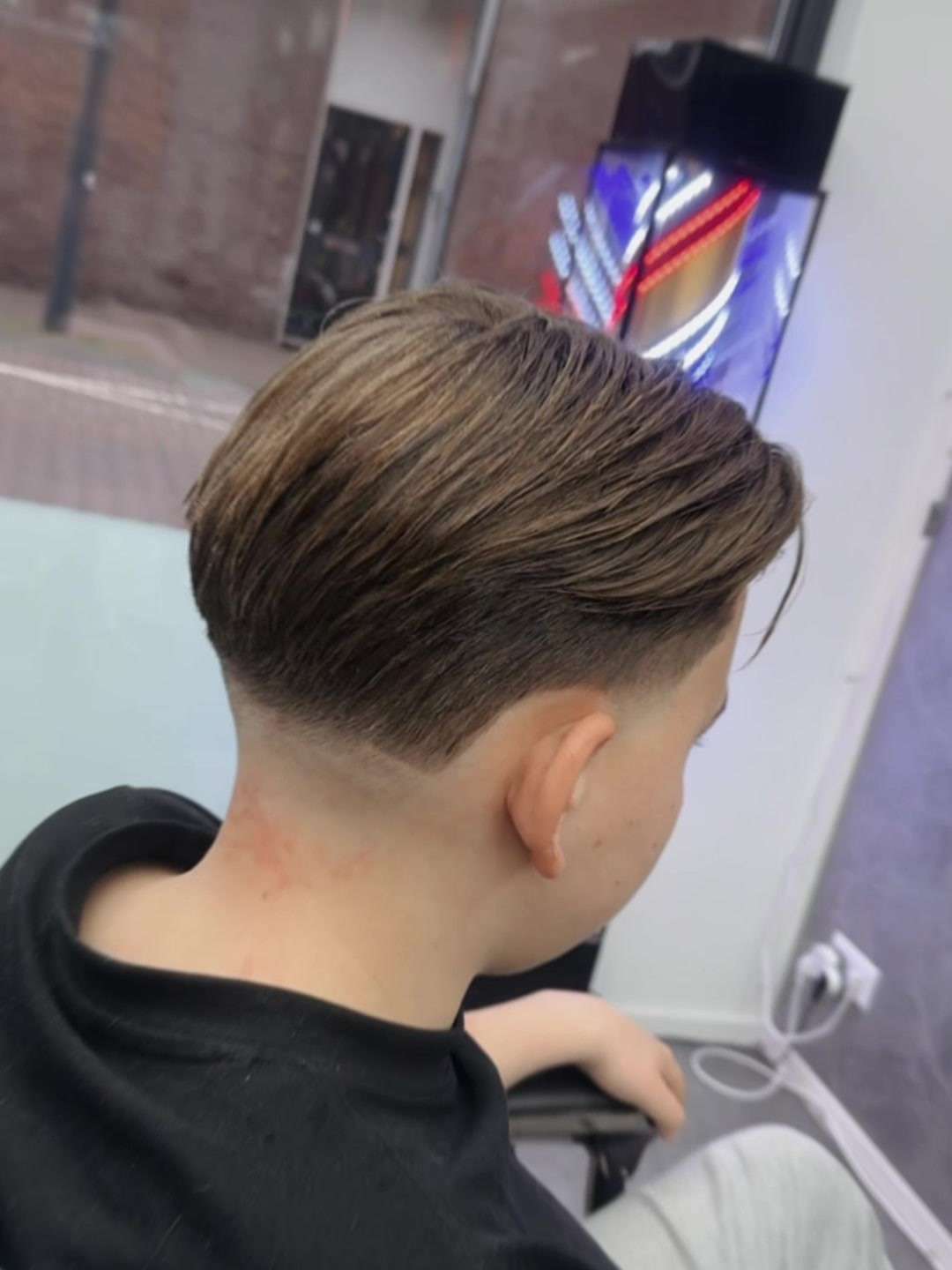 Taper in de nek met lengte bovenop, naar achteren gestyled, bij City Style Barbershop
